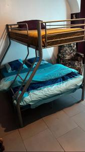 two bunk beds in a room with blue sheets at la chambre de Jade in Hirson