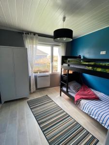 1 dormitorio con litera y pared azul en Maison de plain pied proche Honfleur et Deauville, en Beuzeville