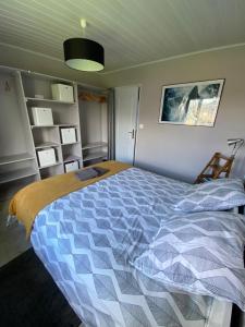 1 dormitorio con 1 cama con edredón azul y blanco en Maison de plain pied proche Honfleur et Deauville, en Beuzeville