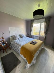 1 dormitorio con cama y ventana grande en Maison de plain pied proche Honfleur et Deauville, en Beuzeville