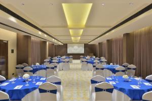 una sala banchetti con tavoli e sedie blu e bianchi di URBANE BY TREAT a Daman