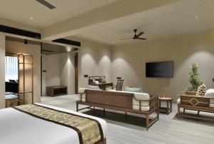 a bedroom with a bed and a living room at URBANE BY TREAT in Daman