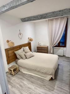 um quarto com uma cama grande e uma janela em Appartement T2 centre village em Cucuron
