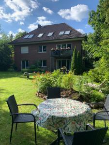 a table and chairs in front of a house at Sonniges Garten-Apartment in ruhiger Parklage in Bad Segeberg