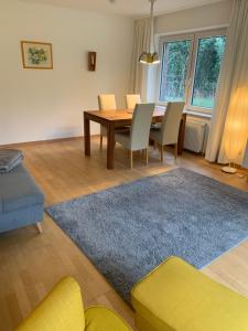 a living room with a dining room table and chairs at Sonniges Garten-Apartment in ruhiger Parklage in Bad Segeberg