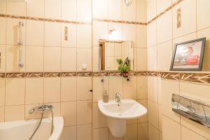 uma casa de banho branca com um lavatório e um espelho em Kraków Charm em Cracóvia
