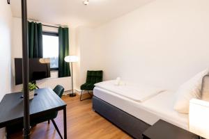 a bedroom with a bed and a desk and a tv at Dream Factory by Hotel Bergheim in Bergheim