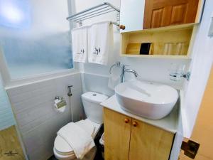 a bathroom with a white toilet and a sink at MP Apartments Leyte in Hindang +19 photos