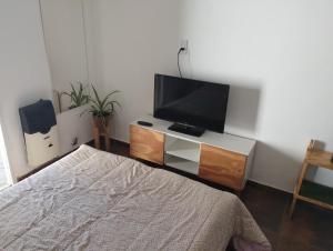 a bedroom with a bed and a flat screen tv at Casa San Clemente del Tuyú in San Clemente del Tuyú