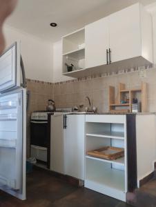 a kitchen with white cabinets and a sink at Casa San Clemente del Tuyú in San Clemente del Tuyú