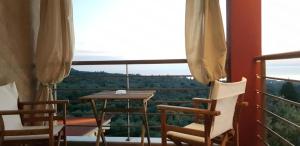 a balcony with a wooden table and two chairs at Villanta 2 in Kallirákhi