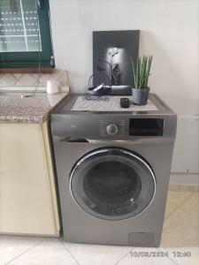 a washing machine in a kitchen with a plant at HOME SWEET HOME Διαμέρισμα 50τμ σε ήσυχη περιοχή in Orestiada