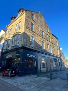 a large brick building on a city street at Top floor apartment in central Buxton in Buxton