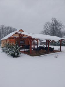 KaszóTölgyfa vendégházak的雪中带雪盖屋顶的小屋