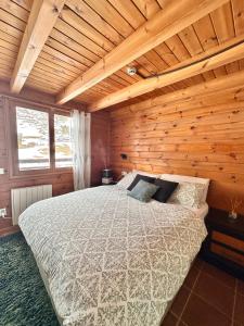 um quarto com uma cama num quarto de madeira em Exclusiva Cabaña en Vall D'Incles - Pistas de Ski & Vistas al Valle - Parking Incluido em Canillo