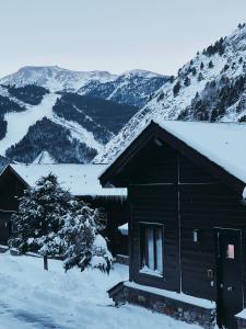 a cabin in the snow with mountains in the background at Exclusiva Cabaña en Vall D'Incles - Pistas de Ski & Vistas al Valle - Parking Incluido in Canillo