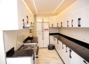 a kitchen with white cabinets and black counter tops at Homestead Realestate in Addis Ababa