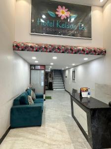 un vestíbulo con un sofá azul en un edificio en Hotel Kelson Dx, en Nueva Delhi