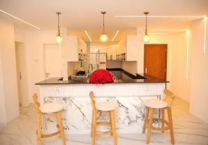 a kitchen with a counter with three stools at Homestead Realestate in Addis Ababa