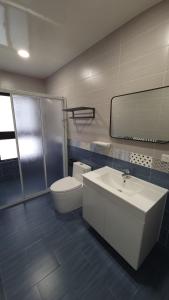 La salle de bains est pourvue d'un lavabo, de toilettes et d'un miroir. dans l'établissement Star Wishes B&B, à Huxi