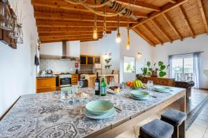 una cocina con una mesa con platos y copas de vino en AnchorHouse Portugal, en Aljezur