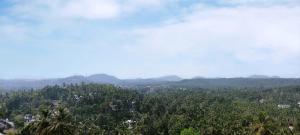 a view of a forest with mountains in the background at Mountain View Villa in Mukkam