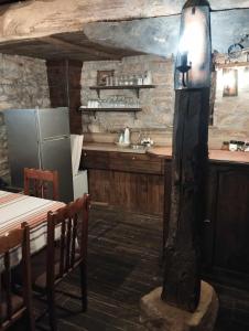 uma cozinha com um frigorífico, uma mesa e um lavatório em Расимова къща em Bozhentsi