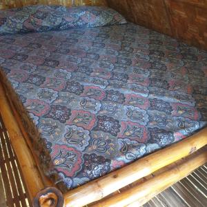 a bed with a quilt on top of it at Era's Garden Homestay in Catmon