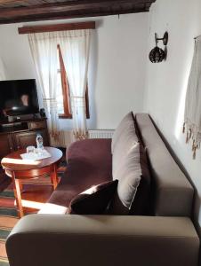 - un salon avec un canapé et une table dans l'établissement Расимова къща, à Bozhentsi