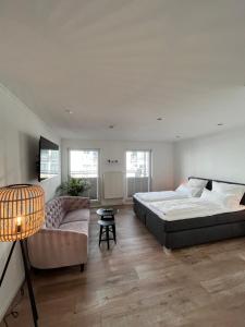 um quarto grande com uma cama e um sofá em Hotel Paula Norderney em Norderney