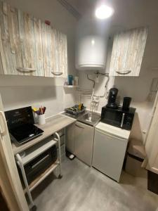 a small kitchen with a sink and a stove at Studio cosy proche centre (CDG) in Charleville-Mézières