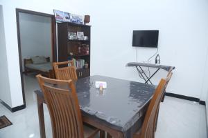 een eetkamer met een tafel en stoelen bij Rose Fort Homestay in Jaffna