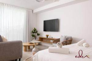 a living room with two beds and a tv at סוויטה משפחתית ליד הים - By Edomlux in Eilat