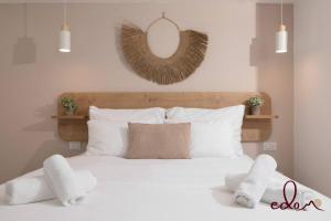 a bedroom with a white bed with a mirror on the wall at סוויטה משפחתית ליד הים - By Edomlux in Eilat +5 photos