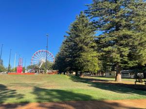 a park with a ferris wheel in the background at Fremantle Harbourside Luxury Apartments in Fremantle