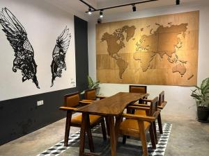 a dining room with a table and a world map on the wall at The Hive Hotel in Siem Reap