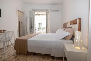 a bedroom with a bed and a table and a chair at B&B - Le Tre Comari in Ragusa