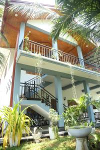 un bâtiment avec balcon et quelques plantes dans l'établissement Rose Fort Homestay, à Jaffna