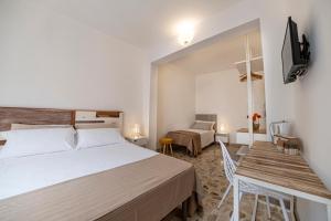a bedroom with a bed and a desk and a television at B&B - Le Tre Comari in Ragusa
