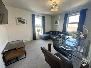 a living room with a table and a couch at COASTAL RETREAT Town Centre Entire Property, Very Close to Sea & Restaurants, 2 King Size Beds in Porthcawl
