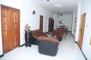 sala de estar con 2 sillas y mesa en Rose Fort Homestay, en Jaffna
