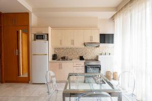 een keuken met een glazen tafel en een witte koelkast bij Elena’s Sweet Home in Downtown Chania in Chania