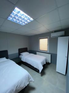 sypialnia z 2 łóżkami i świetlikiem w obiekcie MARİNO HOTEL w mieście Gulyali