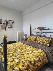 a bedroom with a large bed with a yellow blanket at Polys Apartment and Paraskevi studio with view in Ptolemaida