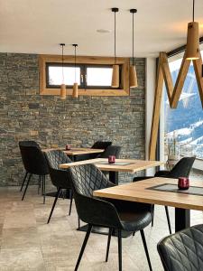 een restaurant met tafels en stoelen en een bakstenen muur bij Residence Garni Melcherhof in Racines