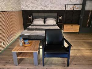 ein Schlafzimmer mit einem Bett, einem Stuhl und einem Tisch in der Unterkunft Wohnung Saarbrücken, City und Uni Nähe mit Parkplatz in Saarbrücken