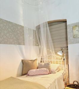 - une chambre avec un lit à baldaquin et une fenêtre dans l'établissement La casa dei nonni, à Bracelli