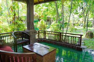 a patio with a table and chairs next to a pool at Panorama cottages 1 #31 in Legian