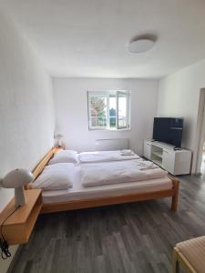 um quarto com uma cama grande e uma televisão em Počitniški dom Portorož / Portoroz Holiday Home em Portorož