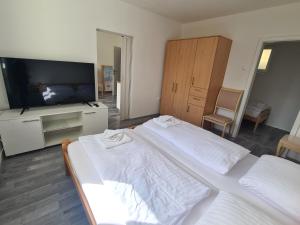 a bedroom with two beds and a flat screen tv at Počitniški dom Portorož / Portoroz Holiday Home in Portorož